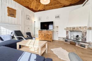 a living room with a tv and a fireplace at Chalupa pod stromy in Kovářská