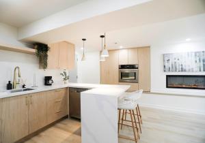 uma cozinha com armários de madeira e uma bancada branca em The Ember Suite em Peterborough