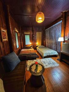 a living room with a couch and a table at Thai Classic House Rimtalay in Ban Rong Po