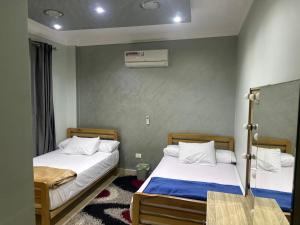 2 Betten in einem kleinen Zimmer mit Nervenkitzel in der Unterkunft Gardinia City luxury Home with 3bed rooms and private pool in Kairo