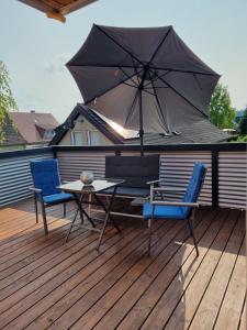 a patio with a table and two chairs and an umbrella at Ferienwohnung Wienstroer in Westbevern