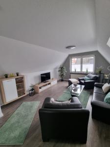 a living room with two couches and a tv at Ferienwohnung Wienstroer in Westbevern