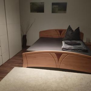 a bed with a wooden headboard in a room at Fewo Am Waldrand in Heideblick