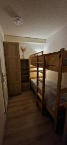 Cette petite chambre comprend 2 lits superposés et une porte. dans l'établissement Studio Super-Besse - 4 personnes, à Besse-et-Saint-Anastaise