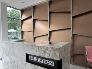 ein Empfangstresen mit einem Reputationsschild an der Wand in der Unterkunft Lang Retreat Apartment - Resort Pool & Elite Gym in Ho-Chi-Minh-Stadt + 91 Fotos