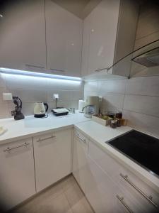a white kitchen with white cabinets and a sink at Theo Luxury House in Patra +23 photos