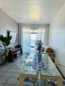 una sala de estar con una mesa y un sofá en De frente ao MAR, en Saquarema