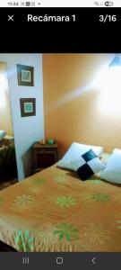 ein Schlafzimmer mit einem Bett und einem Nachttisch mit einer Lampe in der Unterkunft Casa a metros de la playa in Mar del Plata