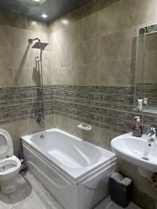 ein Badezimmer mit Badewanne, Toilette und Waschbecken in der Unterkunft Gardinia City luxury Home with 3bed rooms and private pool in Kairo + 24 Fotos