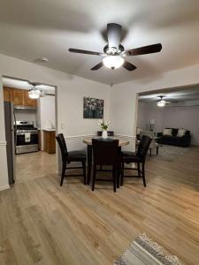 Entire Cozy Apartment Fully Renovated Modern Style في نورث برونزويك: غرفة معيشة مع مروحة سقف وطاولة وكراسي