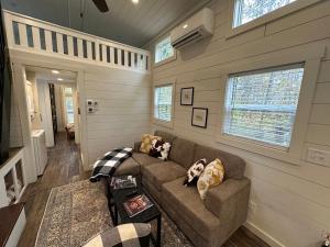 a living room with a couch and a window at Moon River Mentone 1-A Riverfront Tiny Home in Mentone