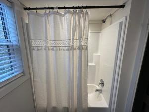 a bathroom with a shower curtain and a sink at Moon River Mentone 1-A Riverfront Tiny Home in Mentone +15 photos