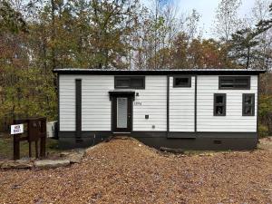 a small white house with a black roof at Moon River Mentone 1-A Riverfront Tiny Home in Mentone