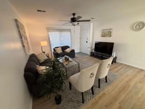 Entire Cozy Apartment Fully Renovated Modern Style في نورث برونزويك: غرفة معيشة مع أريكة وطاولة وكراسي