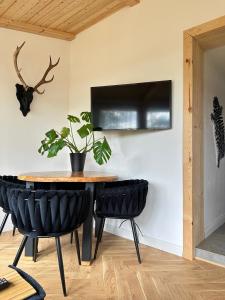 a table and chairs with a plant on a wall at Domek Sosna 