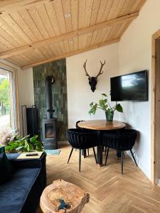 a living room with a table and a fireplace at Domek Sosna 
