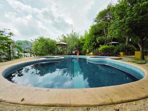 a large swimming pool with blue water at Cabañas el Nido de la Huilota in Tepoztlán