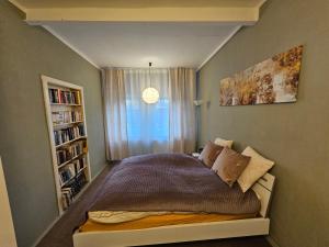 a small bed in a small room with a window at Alte Bibliothek in Kottmar +44 photos