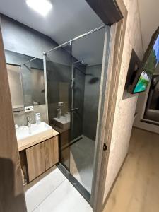 a bathroom with a glass shower and a sink at River House Hotel in Romny +23 photos