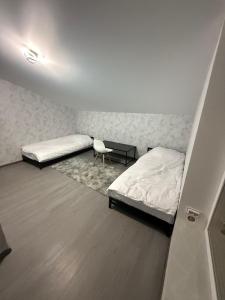 Una habitación con dos camas y una silla dentro. en River House Hotel, en Romny