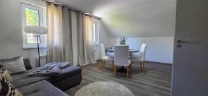 a living room with a couch and a table and chairs at Apartmánová chata u pláže Sečské přehrady in Hoješín