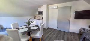 a living room with a table and chairs and a kitchen at Apartmánová chata u pláže Sečské přehrady in Hoješín