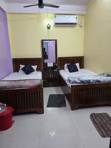 a room with two beds and a mirror in it at Meera Hotel And Lodging in Badarpur