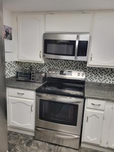 een keuken met roestvrijstalen apparatuur en witte kasten bij Happy night stay room in Winnipeg