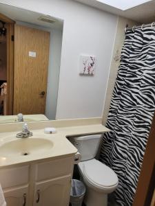 een badkamer met een wastafel en een zebradouchegordijn bij Happy night stay room in Winnipeg