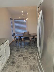 een eetkamer met een tafel met stoelen en een koelkast bij Happy night stay room in Winnipeg