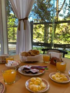 a table with plates of food and glasses of orange juice at Hostería Michel in Villa Gesell