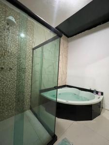 Das Bad ist mit einer Glasdusche und einer Badewanne ausgestattet. in der Unterkunft Hostel and Party Space! in Três Rios