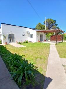 a white building with a grass yard at Casa con Jardín Las Marías 2 in Miramar