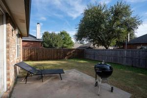 a barbecue grill and a chair in a backyard at Modern 4BR w Natural Light, High Ceilings in Roanoke