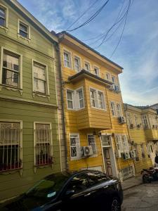 a yellow and green building with a car parked in front at Grand Süleymaniye Hotel in Istanbul +52 photos