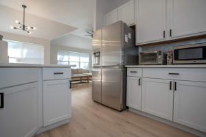 a kitchen with white cabinets and stainless steel appliances at Modern 4BR w Natural Light, High Ceilings in Roanoke