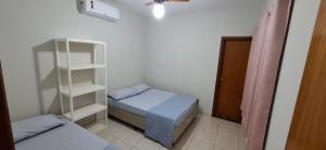 a small bedroom with a bed and a book shelf at bairro Oliveira - casa 3 quartos com ar in Campo Grande
