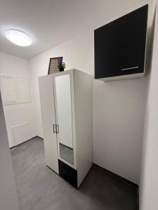 una habitación con un armario blanco y un televisor en la pared en Ruhiges Apartment mit Terrasse an der Donau - Schwaben Living, en Munderkingen