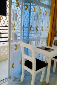 a table and a chair next to a window at Phee home in Mombasa
