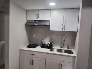 a kitchen with white cabinets and a sink at Elegance Lounge in Winnipeg