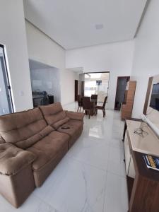 a living room with a brown couch in a room at Casa de 3 Quartos a 500mts da Praia do Araçagy in São Luís