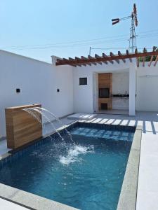 a pool with a water fountain in a house at Casa de 3 Quartos a 500mts da Praia do Araçagy in São Luís