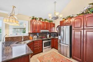 a kitchen with wooden cabinets and a stainless steel refrigerator at Magical Bayfrnt Home, Pier, Beach, Fossils, Trails in Port Republic +79 photos