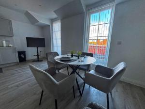 HanwellにあるLuxury 1BR Modern Flat in London W7 with Private Parkingのテーブルと椅子と窓のあるリビングルーム +6枚の写真