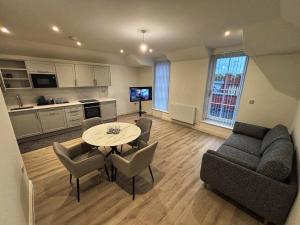 HanwellにあるLuxury 1BR Modern Flat in London W7 with Private Parkingのテーブルと椅子、キッチンのあるリビングルーム