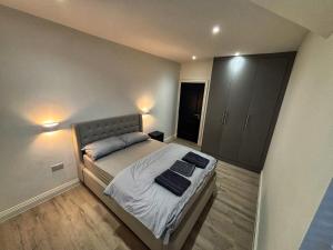 HanwellにあるLuxury 1BR Modern Flat in London W7 with Private Parkingのベッドとタオル2枚のある寝室