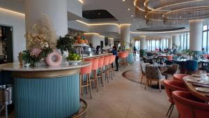 a restaurant with a bar with chairs and tables at Ellipse Lux Hotel - Apartment in Midrand