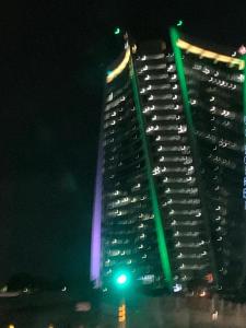 ミッドラントにあるEllipse Lux Hotel - Apartmentの夜間に緑色の灯りを灯す高層ビル