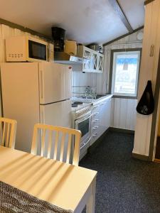 a kitchen with a refrigerator and a table with chairs at Bondasgården in Lima +18 photos