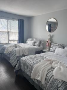 a bedroom with two beds and a mirror and a window at Kickback and relax in Elizabeth